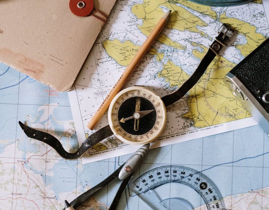 white and black compass beside a pencil